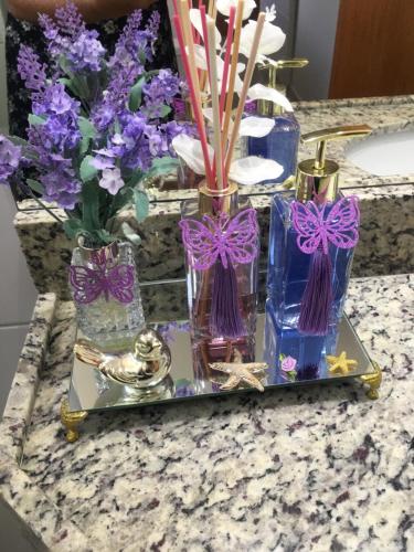 a group of vases with purple flowers on a counter at Apartamento a beira mar com piscina estilo resort in Cabedelo