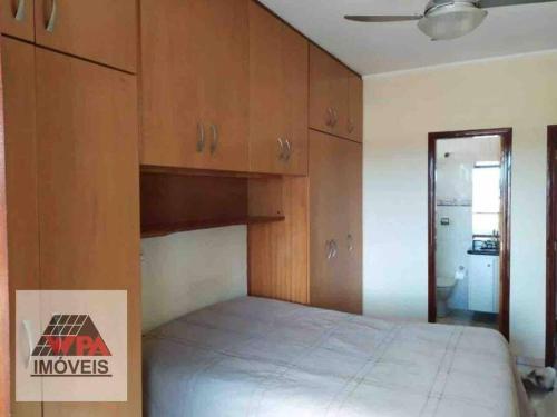a bedroom with a bed and wooden cabinets at Quarto com varanda tipo Airbn b Vista Panorâmica Livre da Cidade in Americana