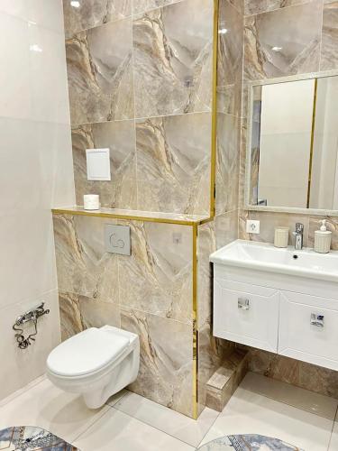 ein Badezimmer mit einer weißen Toilette und einem Waschbecken in der Unterkunft Евродвушка вблизи MegaSilkWay & EXPO in Prigorodnyy