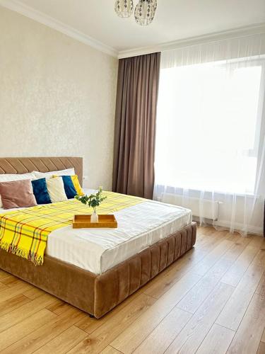 ein Schlafzimmer mit einem großen Bett mit einer gelben und blauen Decke in der Unterkunft Евродвушка вблизи MegaSilkWay & EXPO in Prigorodnyy