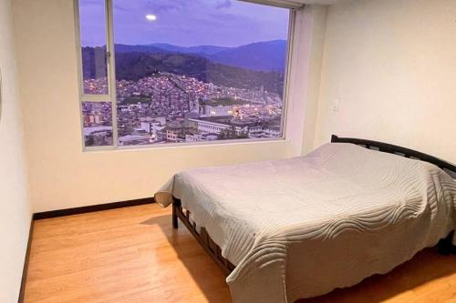マニサレスにあるAv santander apartamento perfecta ubicaciónのベッドルーム1室(ベッド1台、大きな窓付)