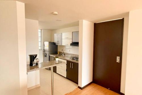 マニサレスにあるAv santander apartamento perfecta ubicaciónの白いキャビネットと黒いドア付きのキッチン