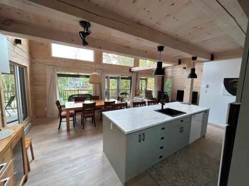 a kitchen and dining room of a log cabin at le vénÉrable in LʼAnse-Saint-Jean