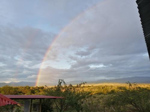 a rainbow in the sky over a field at Payande - Tatacoa in Villavieja