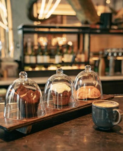 a tray with three pastries in glass domes on a counter at Hotel Fraye Nashville, Curio Collection By Hilton in Nashville