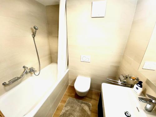 a bathroom with a tub and a toilet and a sink at Chalet Neuf, Morgins in Morgins