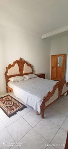 ein Schlafzimmer mit einem großen Bett mit einem Holzrahmen in der Unterkunft appartamenti Oueslati in Houmt Souk