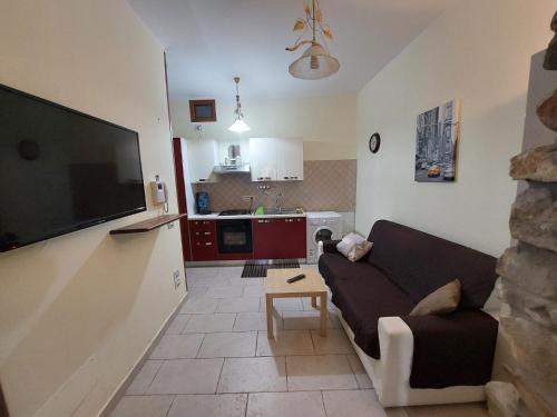 een woonkamer met een bank en een flatscreen-tv bij Cilento Paradise - Appartamento con terrazzo in Marina di Pisciotta in Pisciotta