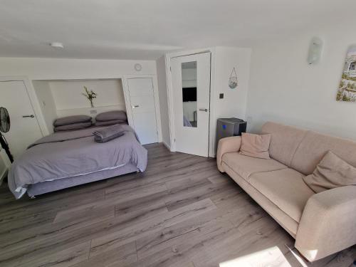 a bedroom with a bed and a couch at GF Studio, Secure parking, outside area, cinema(S) in Hurn