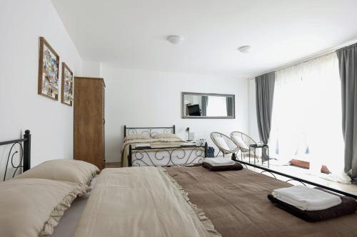 a white bedroom with a bed and a window at Apartman Ari Varaždin - Advent u Varaždinu posebna ponuda in Varaždin