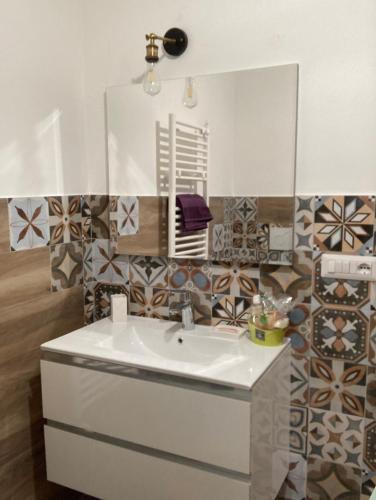 La salle de bains est pourvue d'un lavabo blanc et d'un miroir. dans l'établissement front streat 5, à Sassari