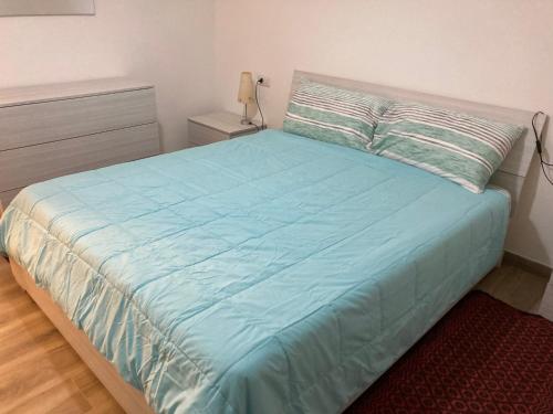 una camera con letto e piumone blu di front streat 5 a Sassari