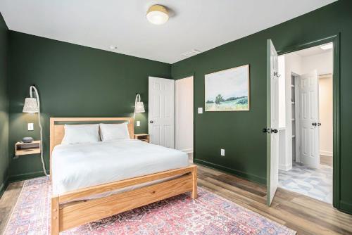 a bedroom with green walls and a bed with a wooden frame at The Neighborhood Hotel Grand Beach in New Buffalo