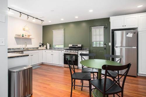 a kitchen with white cabinets and a green wall at The Neighborhood Hotel Grand Beach in New Buffalo