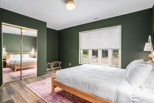 a bedroom with green walls and a bed and a window at The Neighborhood Hotel Grand Beach in New Buffalo