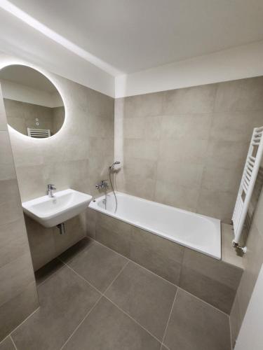 a bathroom with a bath tub and a sink at BA Apartment with free garage parking, huge outside area in Bratislava