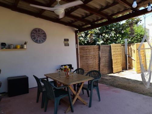 une table en bois avec des chaises et une horloge sur le mur dans l'établissement Villa, maison bord de mer climatisée, à Poggio-Mezzana