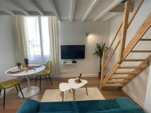 uma sala de estar com um sofá azul e uma mesa em Le Cordelier-Proche marché central et vieux port-wifi haut débit- em La Rochelle