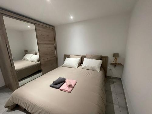 ein Schlafzimmer mit einem Bett und einem rosa Handtuch darauf in der Unterkunft Résidence du Temple in Martigues