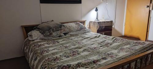 a bedroom with a bed with a floral bedspread at El Adobe Chile Chico in Chile Chico