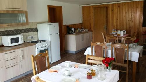 - une cuisine avec une table avec des nappes blanches et des fleurs dans l'établissement Jelena, à Korenica