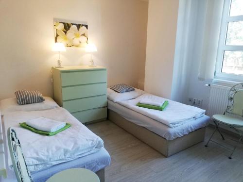 a room with two beds and a dresser in it at Guest House Factory in Malacky