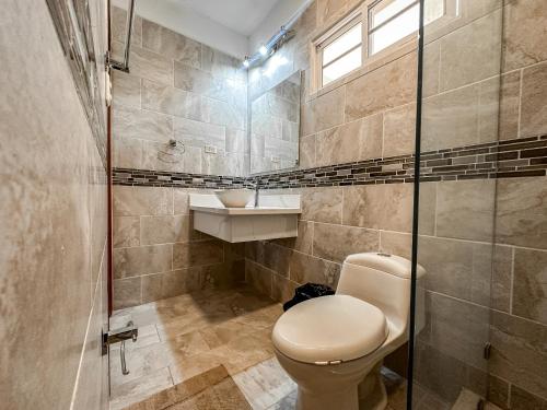 a bathroom with a toilet and a sink at Residencial Del Golf in La Lima