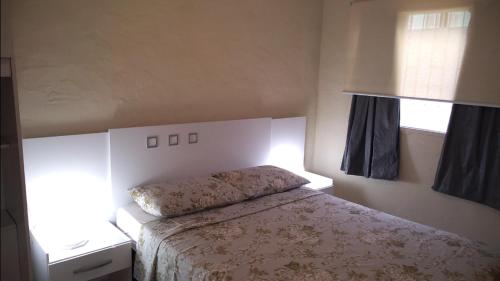 1 dormitorio con cama y ventana en Moradas Lagoinha, en Florianópolis