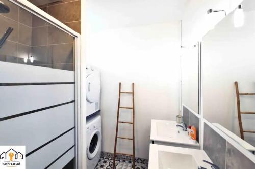 een badkamer met een wastafel en een wasmachine bij Perle Briochine Seh’Loué in Saint-Brieuc