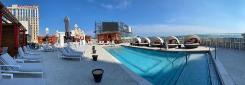 a large swimming pool on a building with chairs at Nobu Hotel at Caesars Atlantic City in Atlantic City