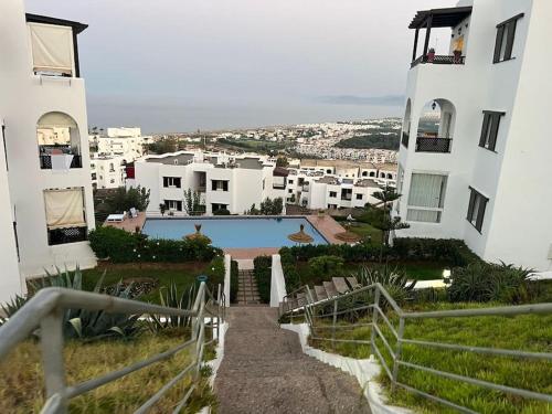 una escalera que conduce a un edificio con piscina en Luxueux VILLA avec jardin et vue panoramique en Tetuán