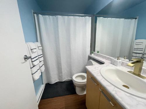 a bathroom with a white toilet and a sink at Downtown 1BR Condo at Granville Strip near English Bay in Vancouver
