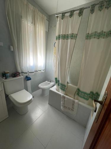 a white bathroom with a toilet and a shower at Casa El Real de San Vicente in El Real de San Vicente