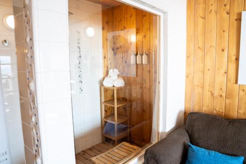 a bathroom with a shower with a wooden wall at Homer Inn & Spa in Homer