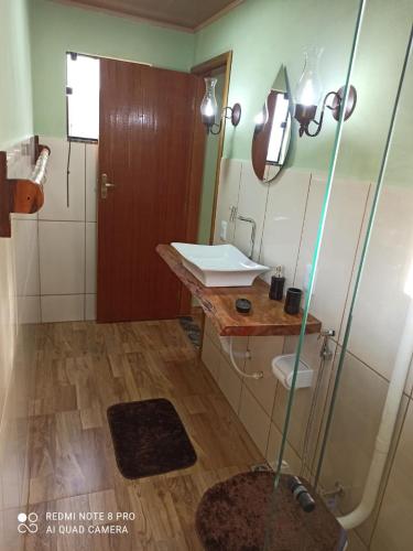 a bathroom with a sink and a shower in it at Chalé Vista do Vale Cangalha in Aiuruoca