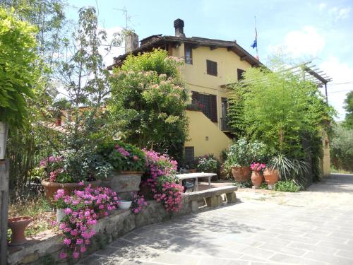 una casa con fiori e una panchina davanti di Agriturismo Le Macine a Firenze