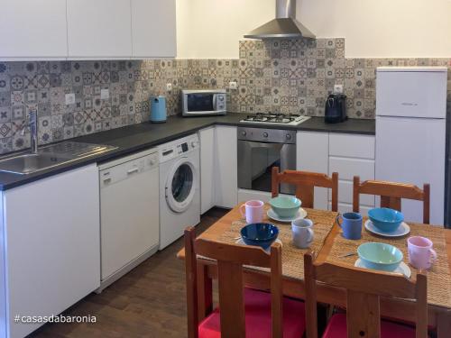 a kitchen with a table and chairs and a sink at casas da Baronia casa Catarina in Vila Nova da Baronia