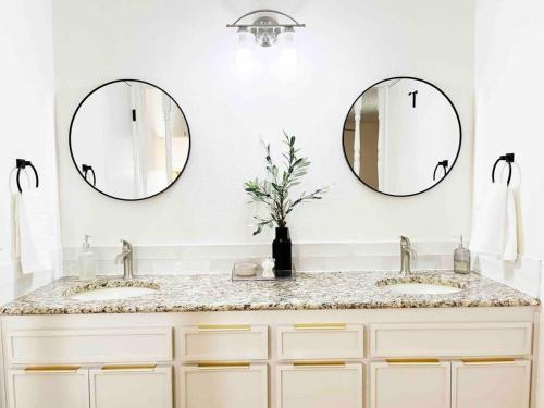 uma casa de banho com dois lavatórios e dois espelhos em NEW*The Wild Cactus- Best of LBK w/TennisCourts em Lubbock