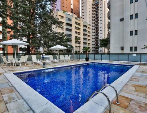 a large swimming pool with chairs and umbrellas at alto padrão itaim bibi in Sao Paulo