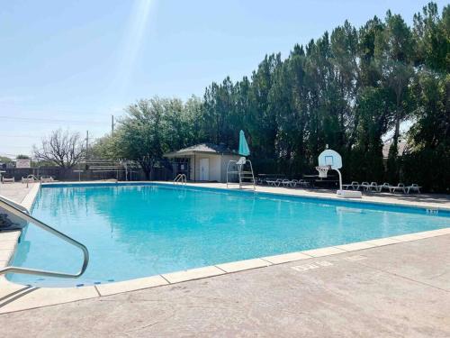 a large blue swimming pool with tables and chairs at NEW*The Wild Cactus- Best of LBK w/TennisCourts in Lubbock