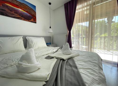 a bedroom with two beds with towels on them at Mountain River Loft in Buşteni