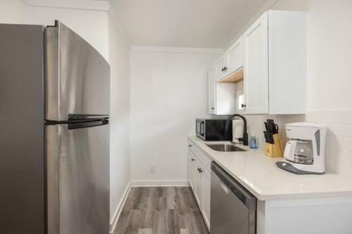 a kitchen with white cabinets and a stainless steel refrigerator at The Coastal Cabana in Panama City Beach