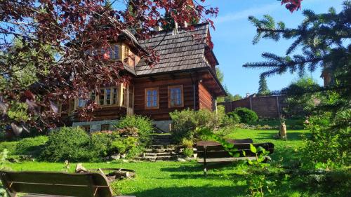 a log cabin with benches in front of it at Dom na Pawlikach in Rzepiska