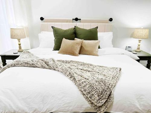 um quarto com uma grande cama branca e 2 candeeiros em NEW Magnolia Mansion-4400sqft Hot Tub & 2 Game Rms em Lubbock