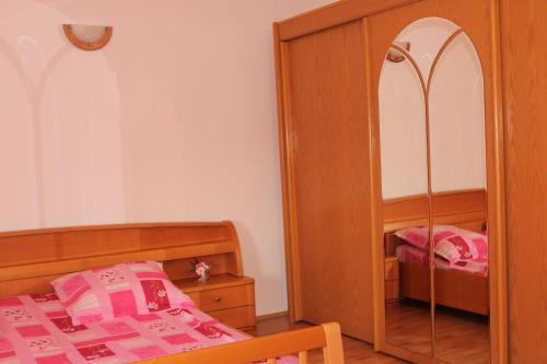 a bedroom with a bed and a mirror at Casa Dănuț in Reşiţa
