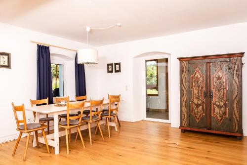 a dining room with a table and chairs and a door at Das Blaue Haus mitten im Grünen - our Blue House surrounded by greenery in Langenaltheim