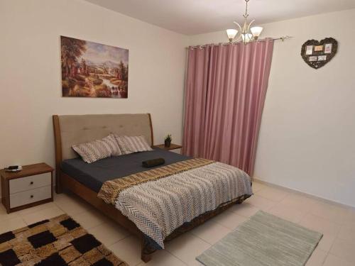 een slaapkamer met een bed en een paars gordijn bij Sea View Studio in Ajman 