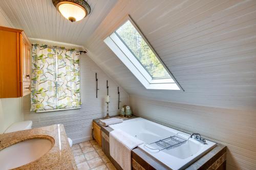 a bathroom with a tub and a sink and a window at Historic Mapleton Cottage with River Views and Hot Tub in Mapleton