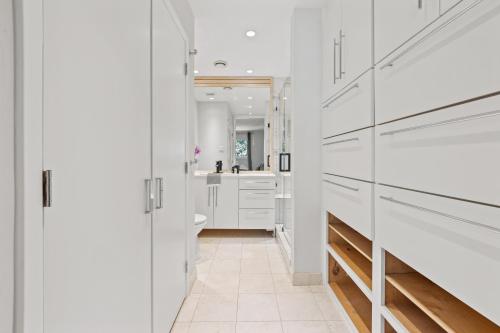 a white bathroom with a toilet and a sink at Luxe and Modern Dallas Condo 2 Mi to Highland Park! in Dallas