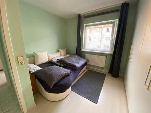 two beds in a small room with a window at Ruhige WE 6 P. urban ÖPNV in Cologne